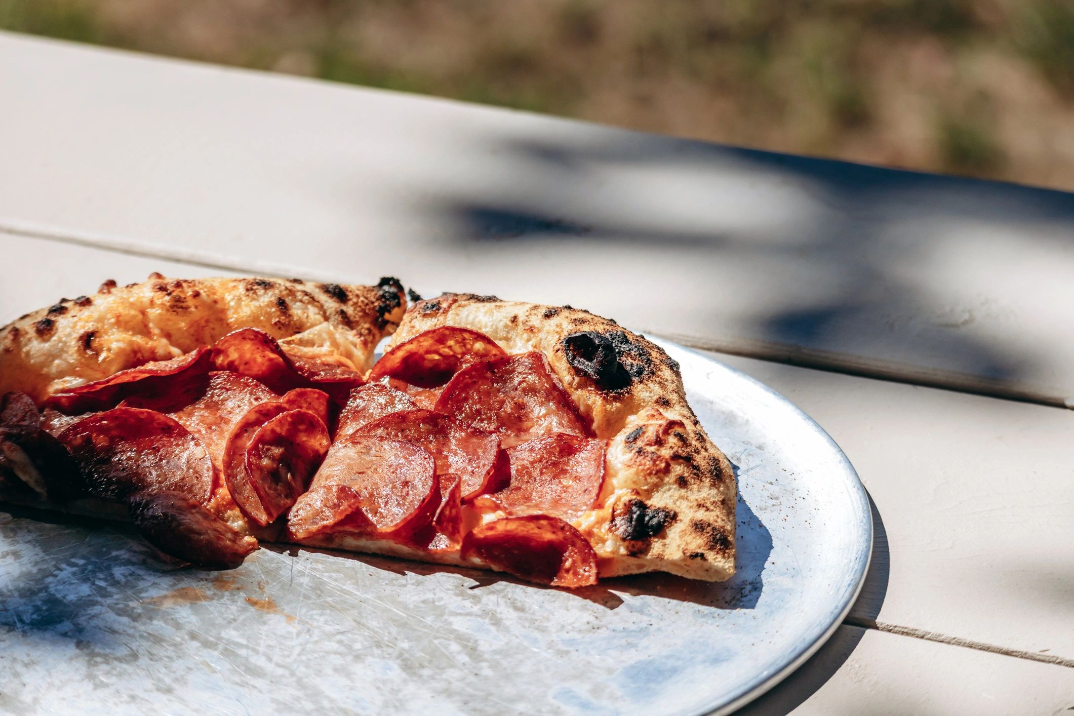Rustic pepperoni pizza slice on tray
